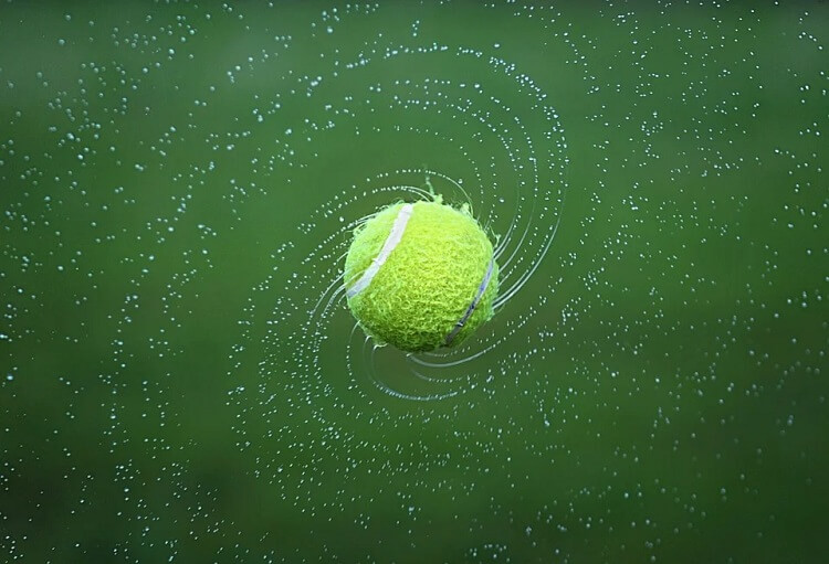 A tennis ball and water droplets