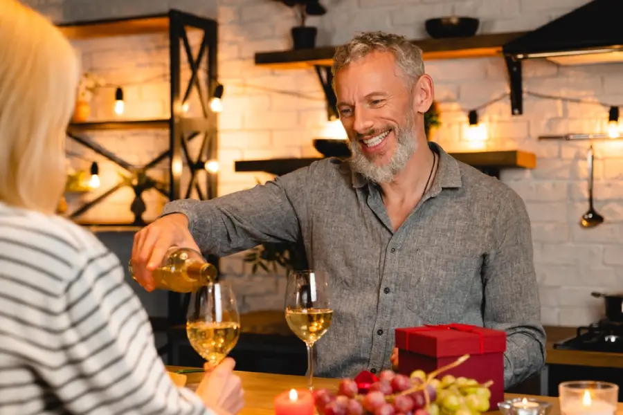 man pouring white wine on a date