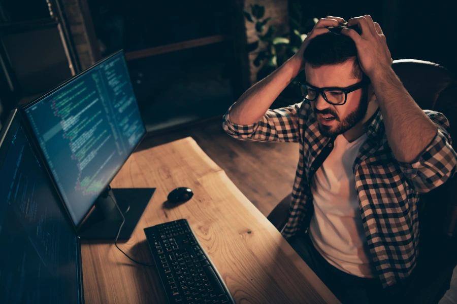 Man pulling at his head looking at code