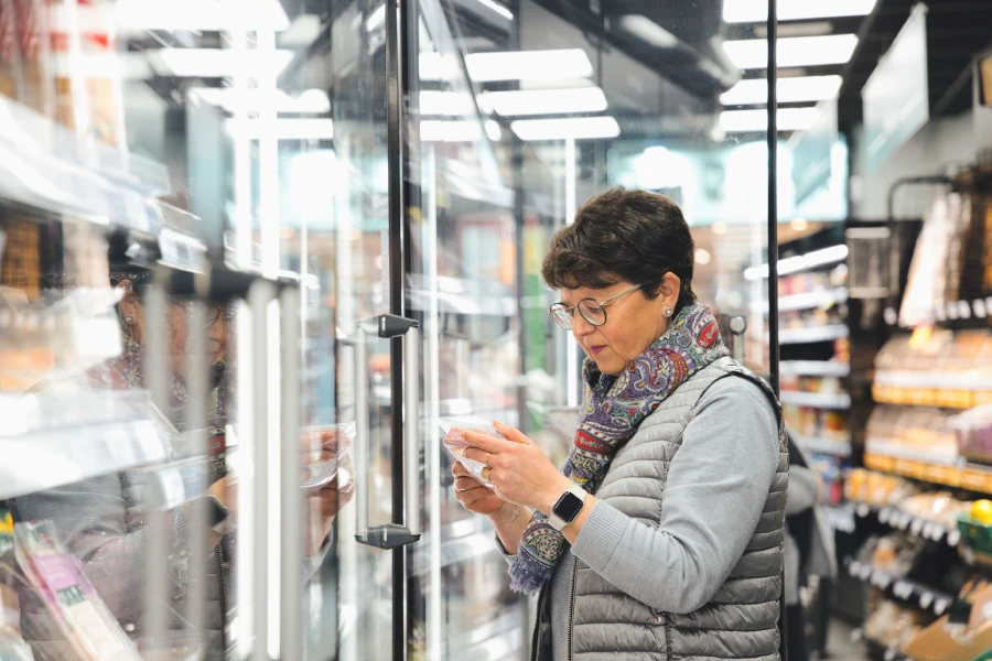 A senior woman with a medical alert smartwatch at the grocery store