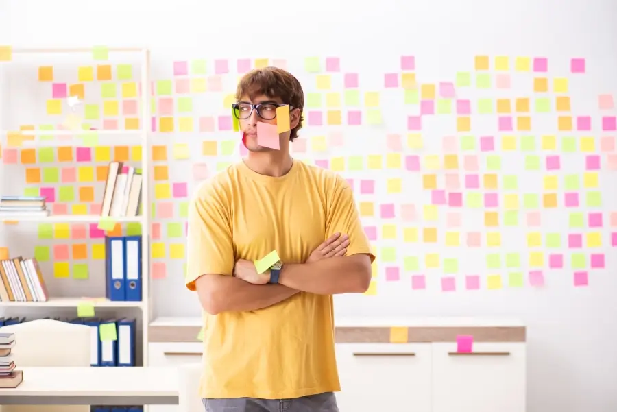 Disorganized man with sticky notes on his face who needs to implement a Kanban